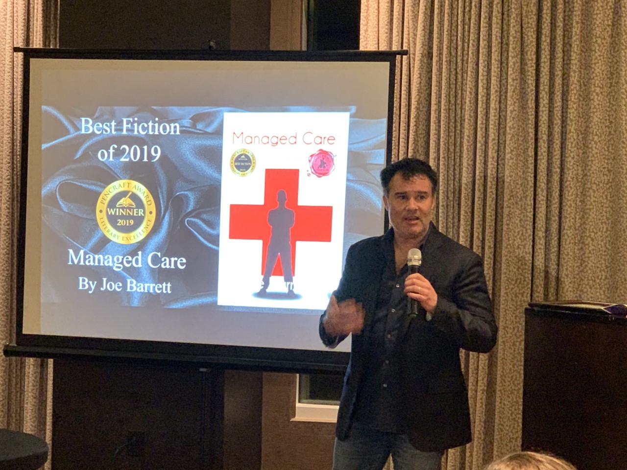 Author Joe Barrett displays his PenCraft Book Award during a presentation.